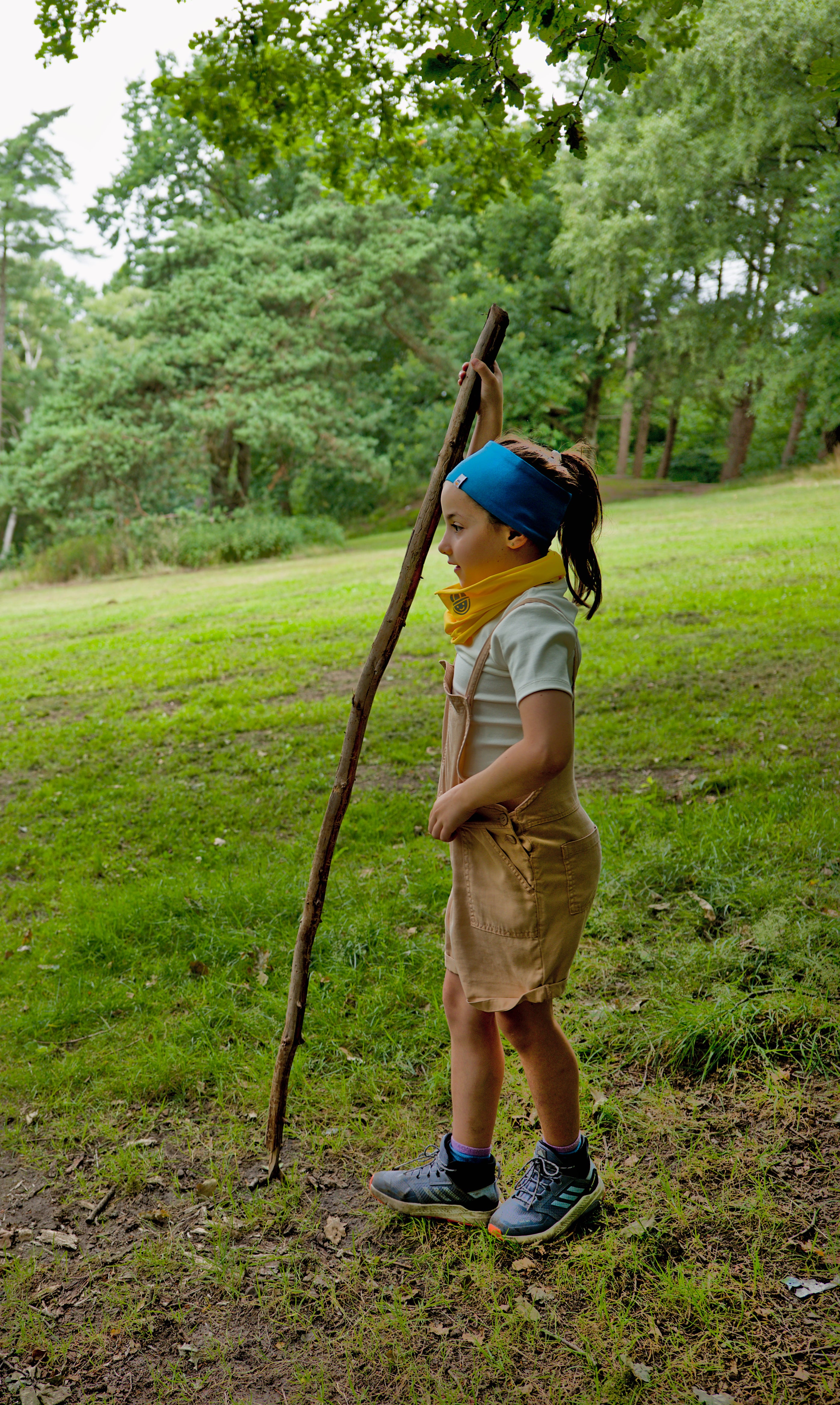 Girl wearing reversible organic cotton headband in blue from the Breeze collection and organic cotton  tubular scarf in yellow with reflective logo from the Vivid collection - The Melon Explorer