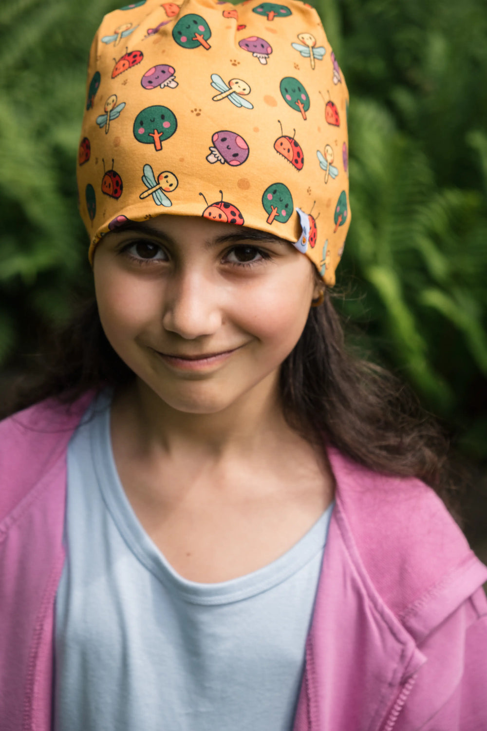 Girl wearing the Woods organic cotton beanie with forest pattern