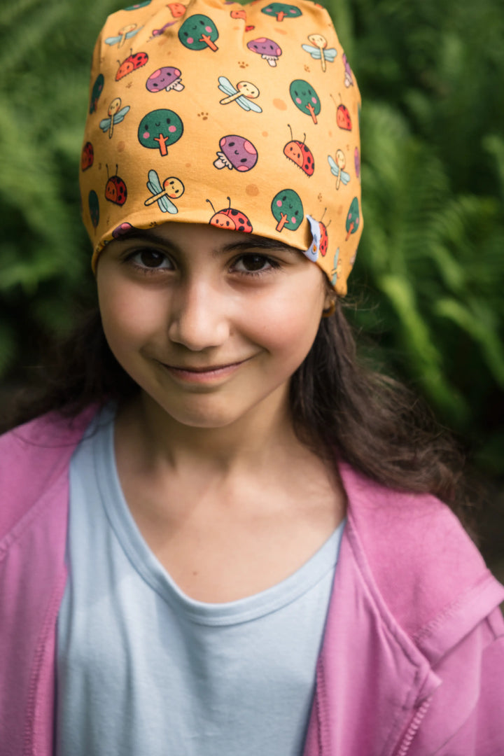 Girl wearing the Woods organic cotton beanie with forest pattern