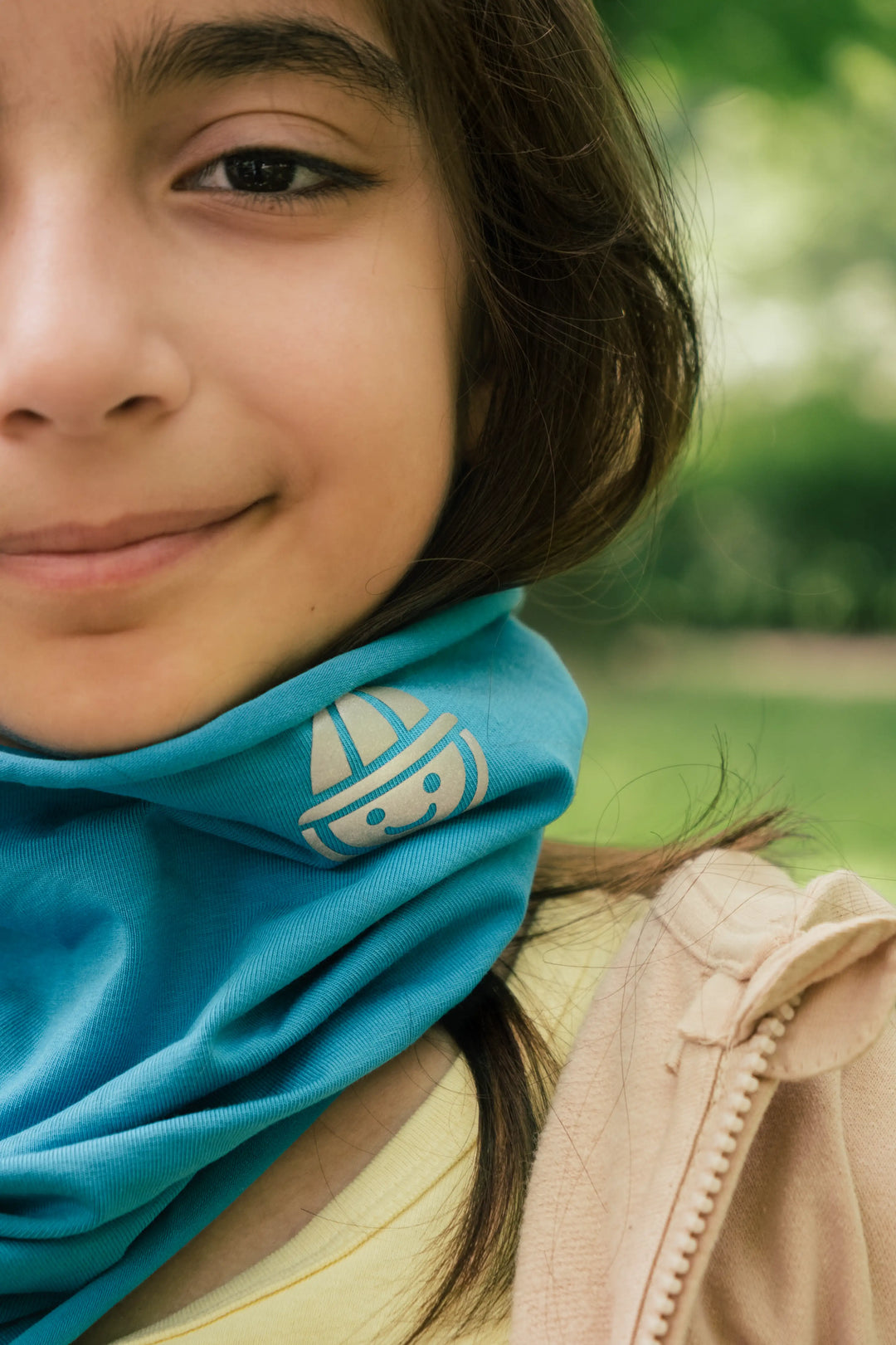 Smiling girl wearing the Vivid organic cotton neck warmer in blue