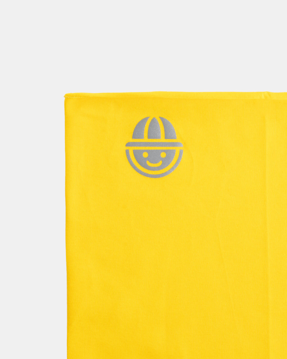 Close-up of reflective logo on yellow organic cotton tubular scarf (neck warmer) from the Vivid collection