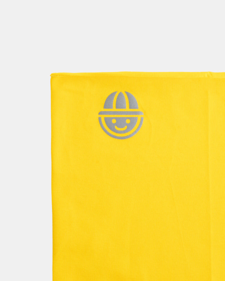 Close-up of reflective logo on yellow organic cotton tubular scarf (neck warmer) from the Vivid collection