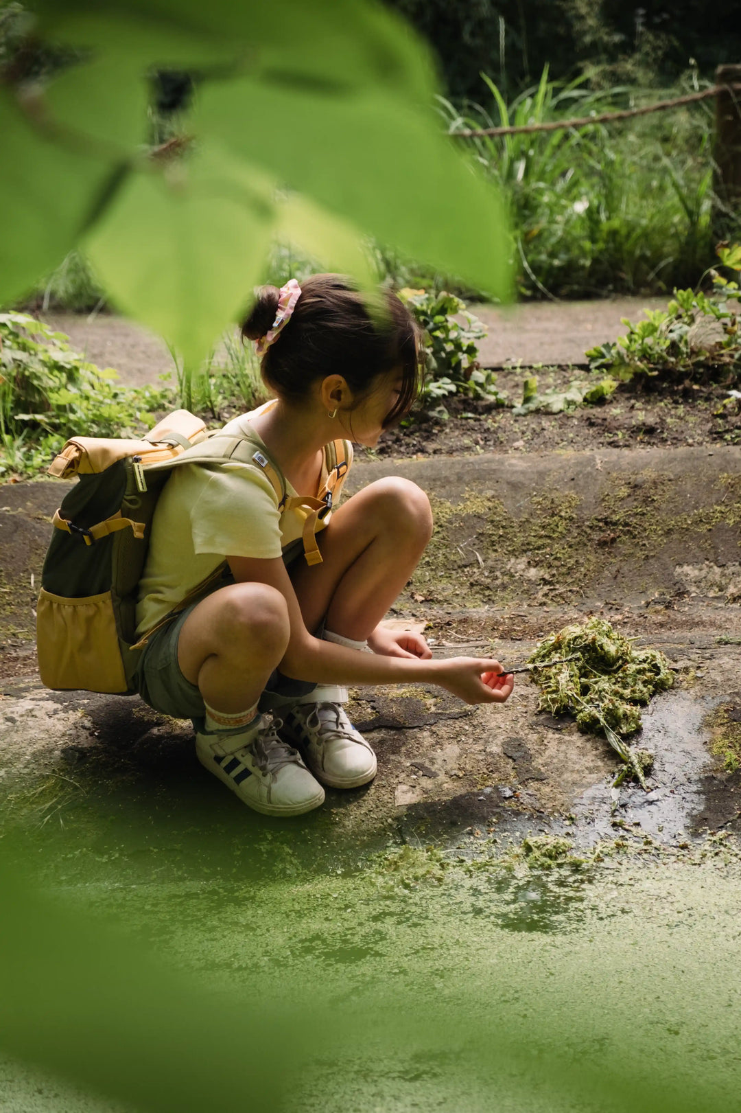 Girl with a Maju recycled polyester backpack exploring a wetland area