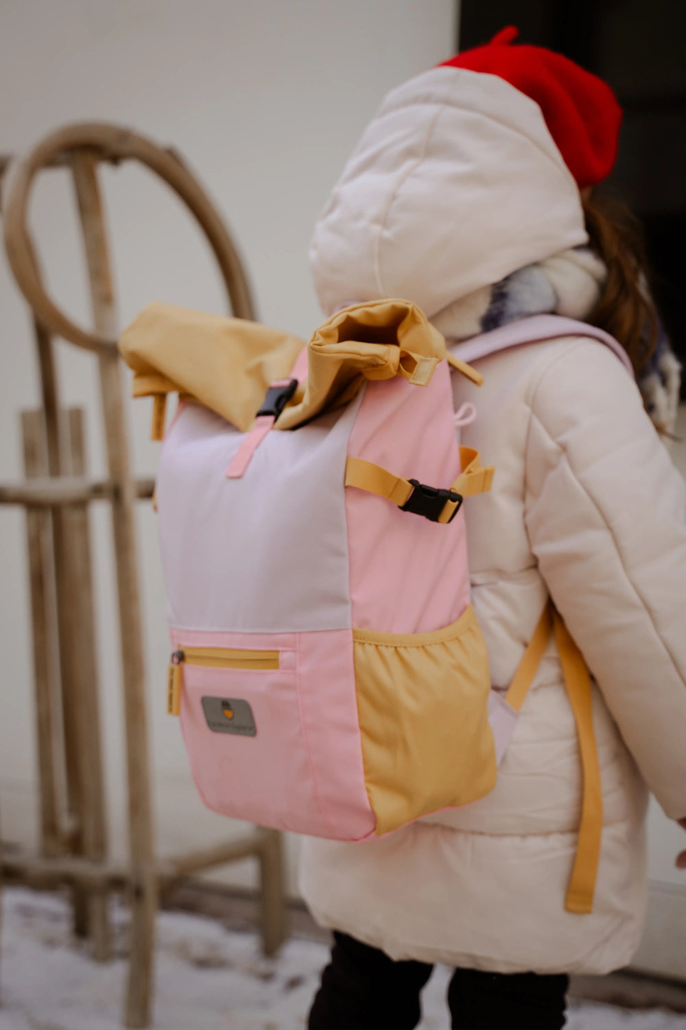 Girl with the recycled rolltop backpack from the Maju collection in pink/purple/orange