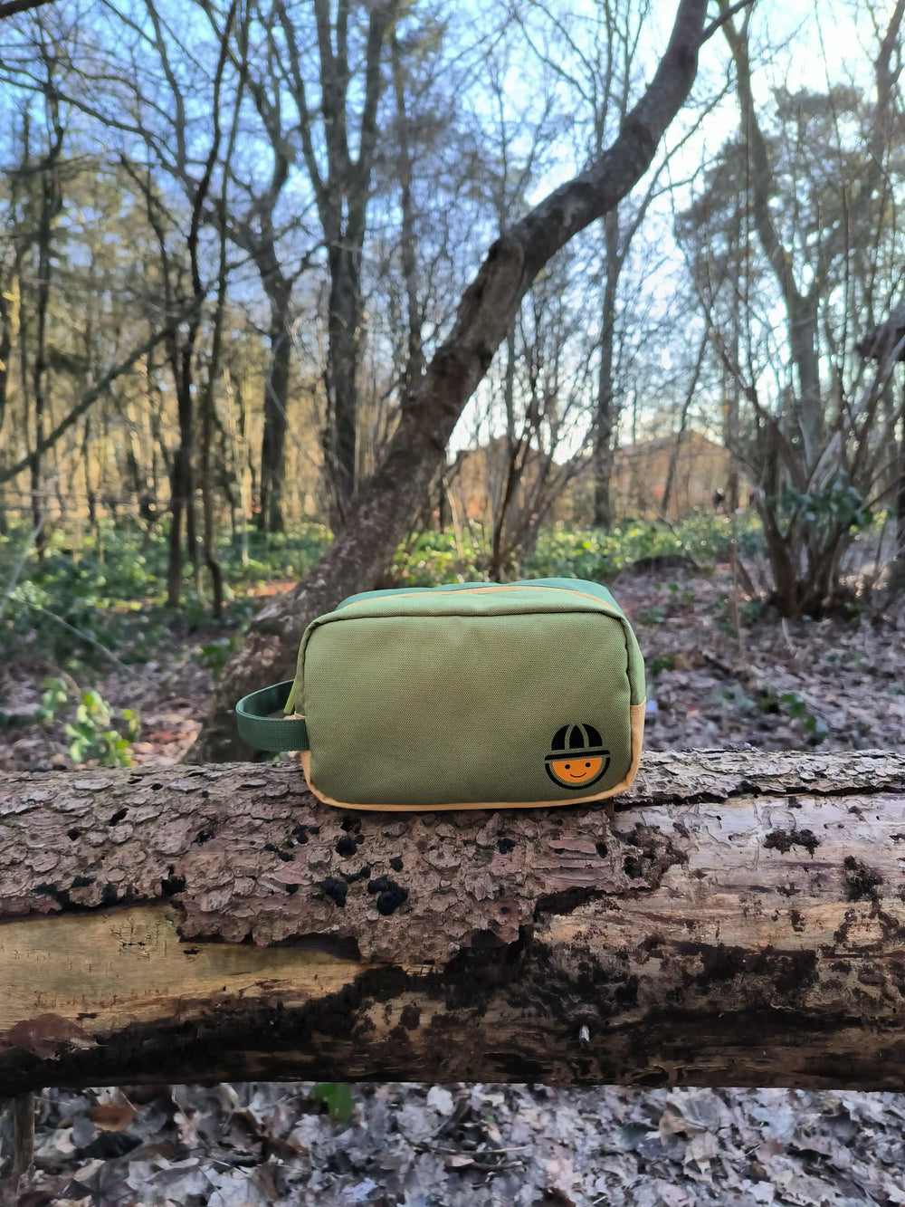 recycled polyester toiletry bag from the collection Maju sitting in the forest