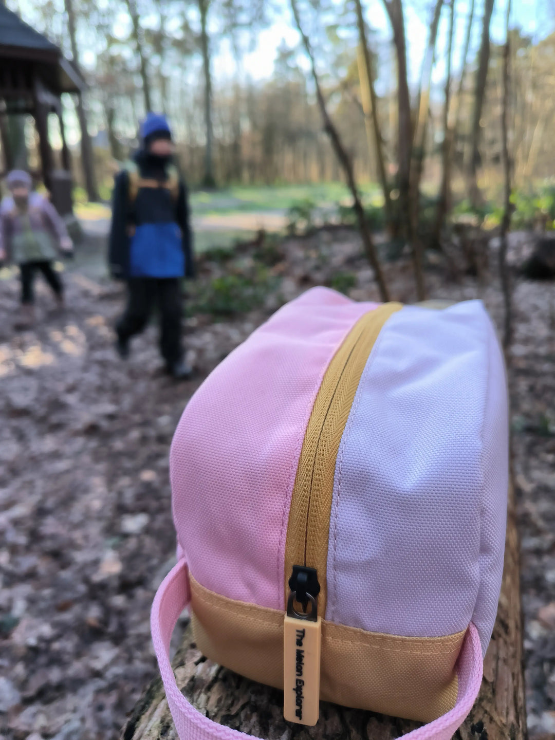 recycled polyester toiletry bag from the collection Maju in pink sitting in the forest 