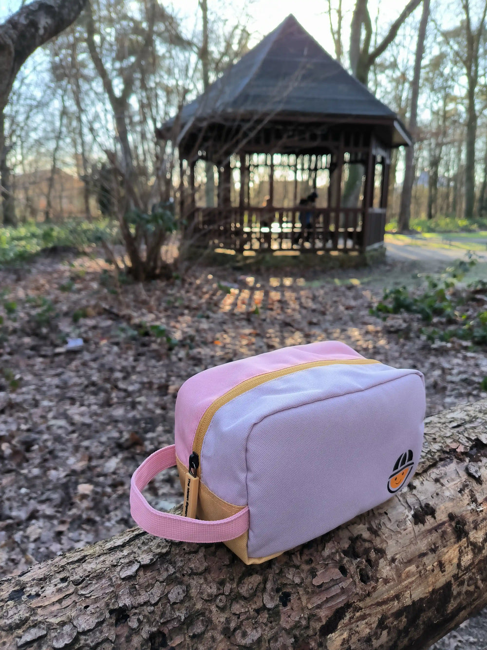 recycled polyester toiletry bag from the collection Maju in pink sitting in the forest 