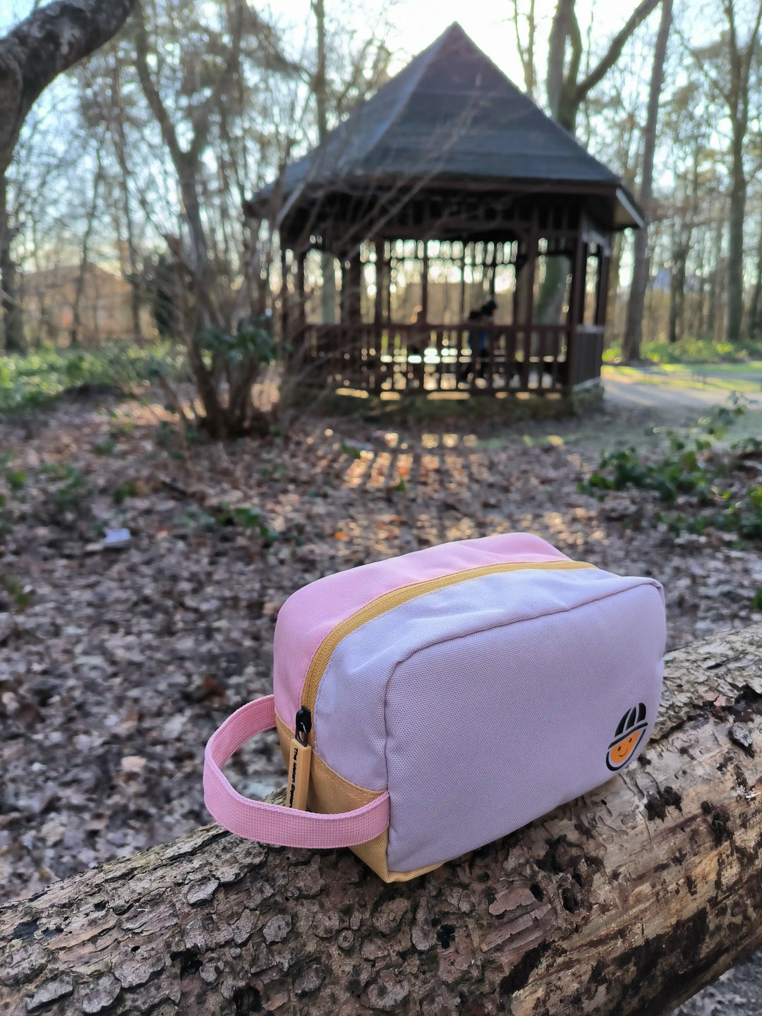 recycled polyester toiletry bag from the collection Maju in pink sitting in the forest 